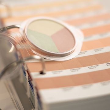 Nahaufnahme einer Farbpalette mit Pastelltönen auf einem ringgebundenen Buch mit Farbmustern, das gedämpfte Grün-, Rosa- und Beigetöne enthält.