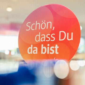 Rundes Schild mit der Aufschrift "Schön, dass du da bist"