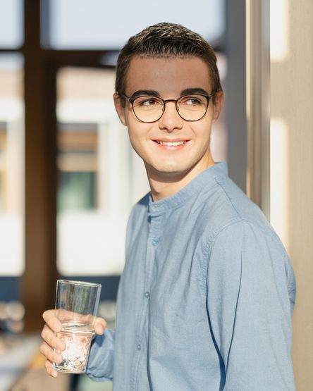 Studierender von dmTECH mit Wasserglas am dm-Unternehmenssitz