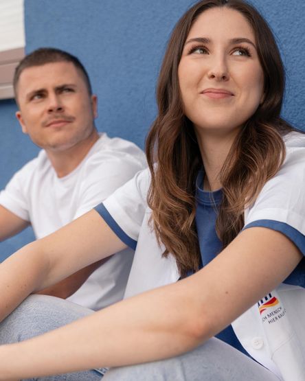 dm-Studierende sitzen vor blauer Wand