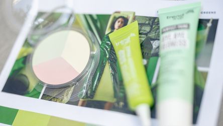 Drei Kosmetikprodukte auf grünem Flyer