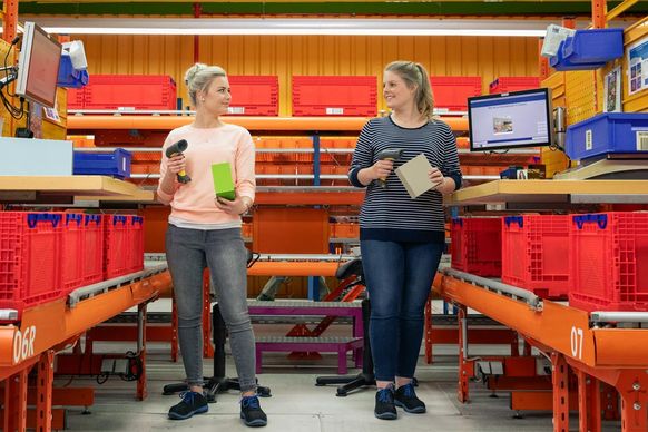 Zwei Studierende kontrollieren Bestellungen am dm-Logistikstandort