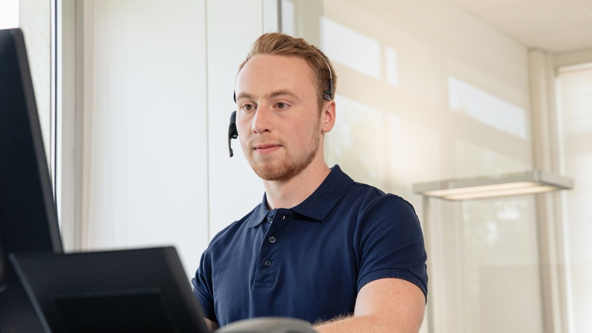 Angehender Fachinformatiker mit Headset am Rechner