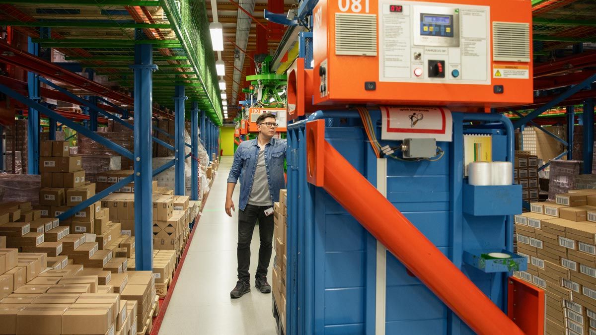 Angehender Fachlagerist kommissioniert Ware mithilfe von Elektrohängebahn im dm-Logistikzentrum