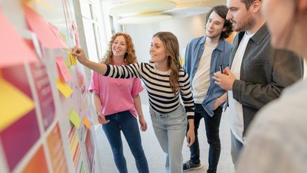 dm-Nachwuchskräfte und Ausbilder brainstormen am Whiteboard mit Post-its