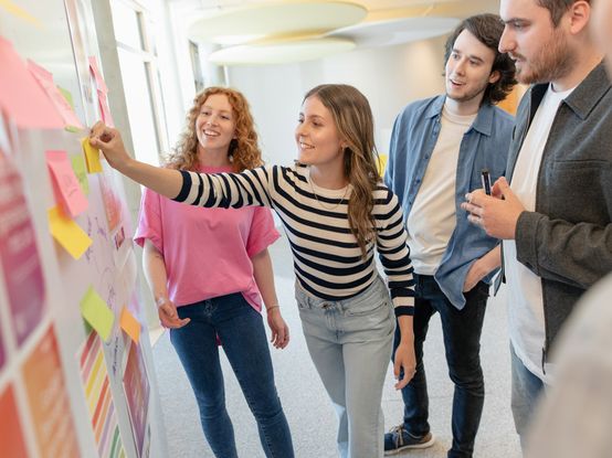 dm-Nachwuchskräfte und Ausbilder brainstormen am Whiteboard mit Post-its