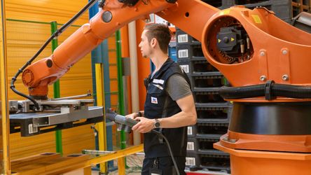 Angehender Mechatroniker testet Steuerungssysteme von Roboterarm