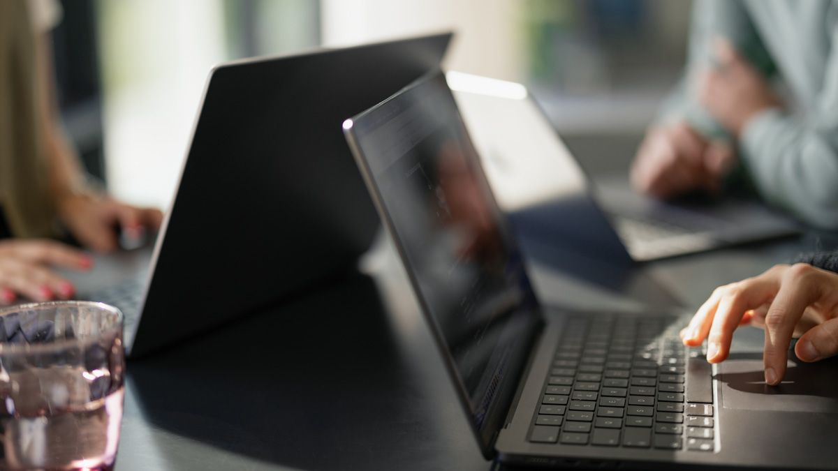 Drei dmTECH-Kollegen vor Laptops