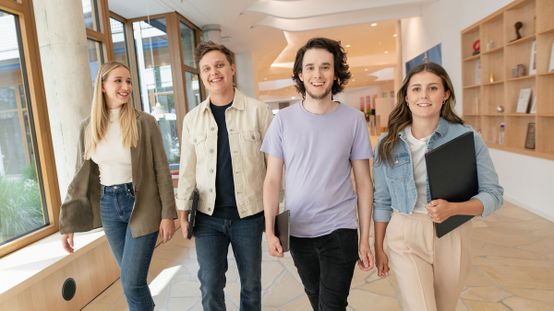 Vier Nachwuchs-Fachkräfte im im Flur im dm-Unternehmenssitz