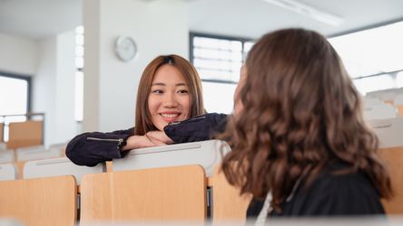 Zwei Studierende im Gespräch im Hörsaal an der Hochschule