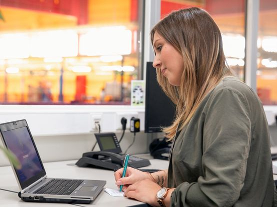 Fachkraft für Lagerlogistik in Ausbildung am Büro-Schreibtisch am dm-Logistikstandort
