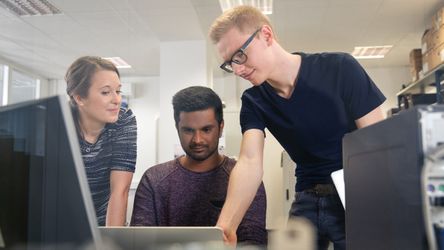 Angehende Fachinformatiker mit Ausbilderin am Rechner im Technikraum