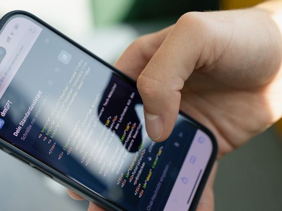 Ein Smartphone mit geöffneter KI-Anwendung in der Hand