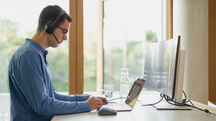 dmTECH-Studierender mit Headeset arbeitet am Laptop im dm-Unternehmenssitz