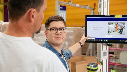 Angehender Fachlagerist überprüft Warenbestand mit Ausbilder