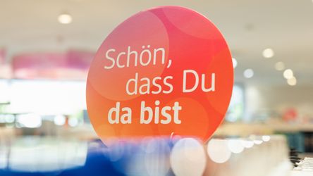 Werbeplakat mit Aufschrift "Schön, dass Du da bist" in dm-Markt