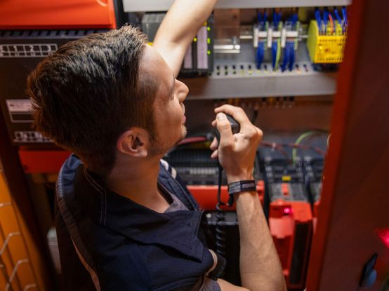 Angehender Elektroniker an Anlage im dm-Logistikzentrum
