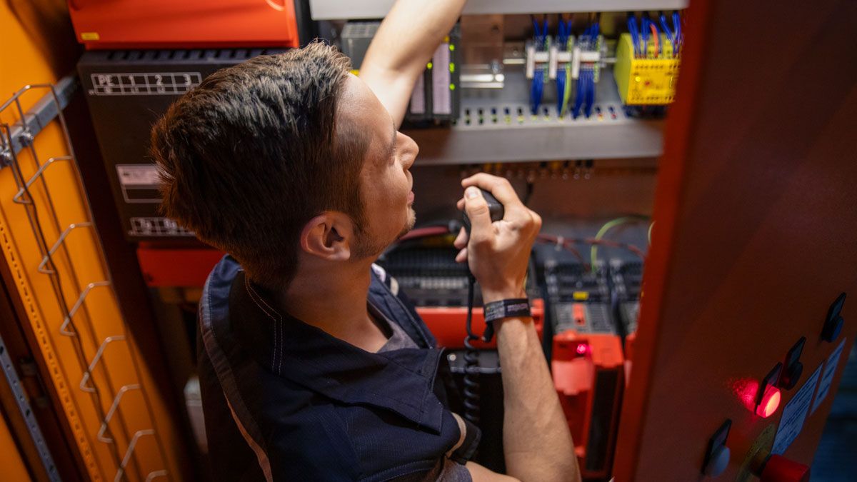 Angehender Elektroniker an Anlage im dm-Logistikzentrum
