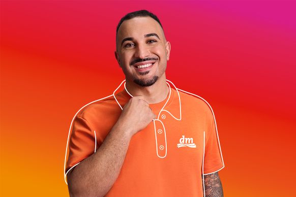 lächelnder dunkelhaariger Mann in dm-Poloshirt