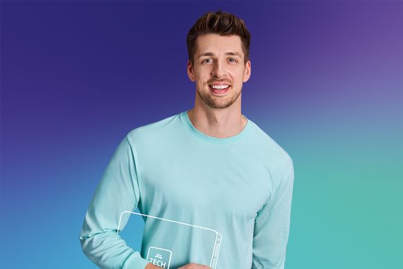 dunkelhaariger junger Mann mit Laptopskizze unter dem Arm