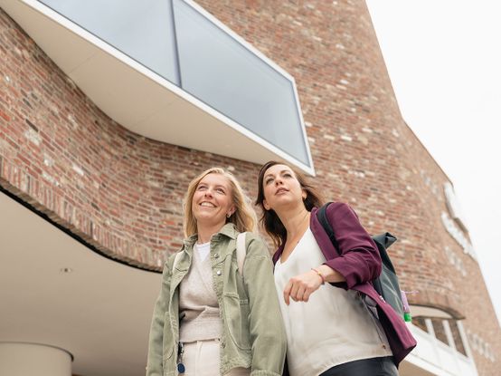 Zwei dm-Mitarbeiterinnen vor dem Unternehmenssitz