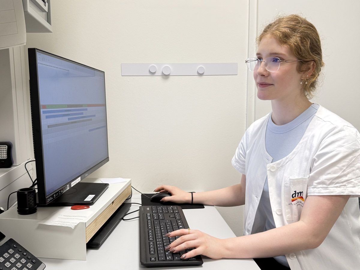 Angehende Drogistin sitzt am Computer und schaut sich den Schichtplan an