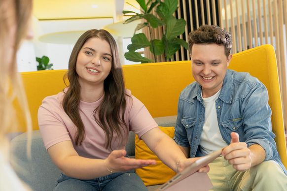 Drei Studierende mit Tablet im Austausch im dm-Unternehmenssitz