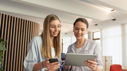 Dual Studierende mit dm-Ausbilderin mit Tablet und Smartphone