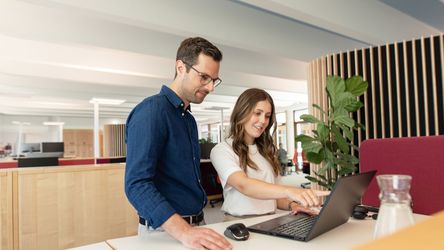 Angehende Kauffrau für Büromanagement und Ausbilder am Laptop im dm-Unternehmenssitz