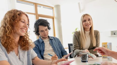 Marketing-Nachwuchskräfte und Ausbilderin schauen sich dm-Produkte an