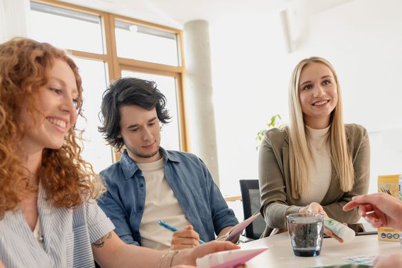 Marketing-Nachwuchskräfte und Ausbilderin schauen sich dm-Produkte an
