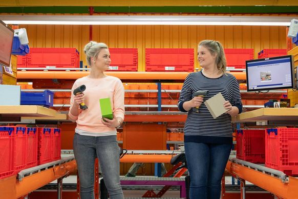 Zwei Studierende prüfen Bestellungen im dm-Logistikzentrum