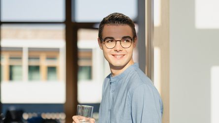 Studierender von dmTECH mit Wasserglas am dm-Unternehmenssitz