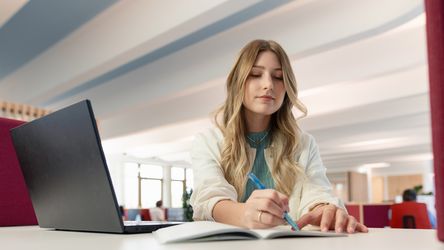 dm-Studierende arbeitet am Laptop im dm-Unternehmenssitz