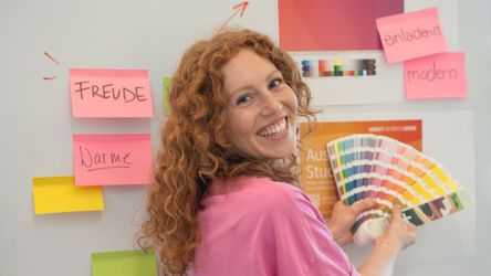 dm-Studierende mit Pantone-Fächer am Whiteboard mit Post-Its